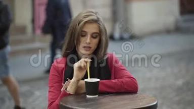 快乐的女孩在街头咖啡馆喝咖啡，真诚地微笑。 4K